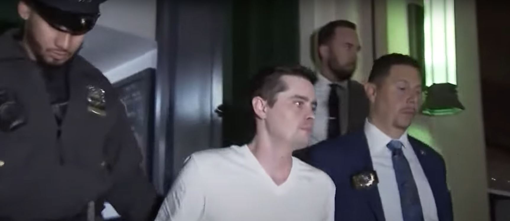 John Woeltz, escorted by police officers, following his arrest for kidnapping and torturing an Italian tourist.