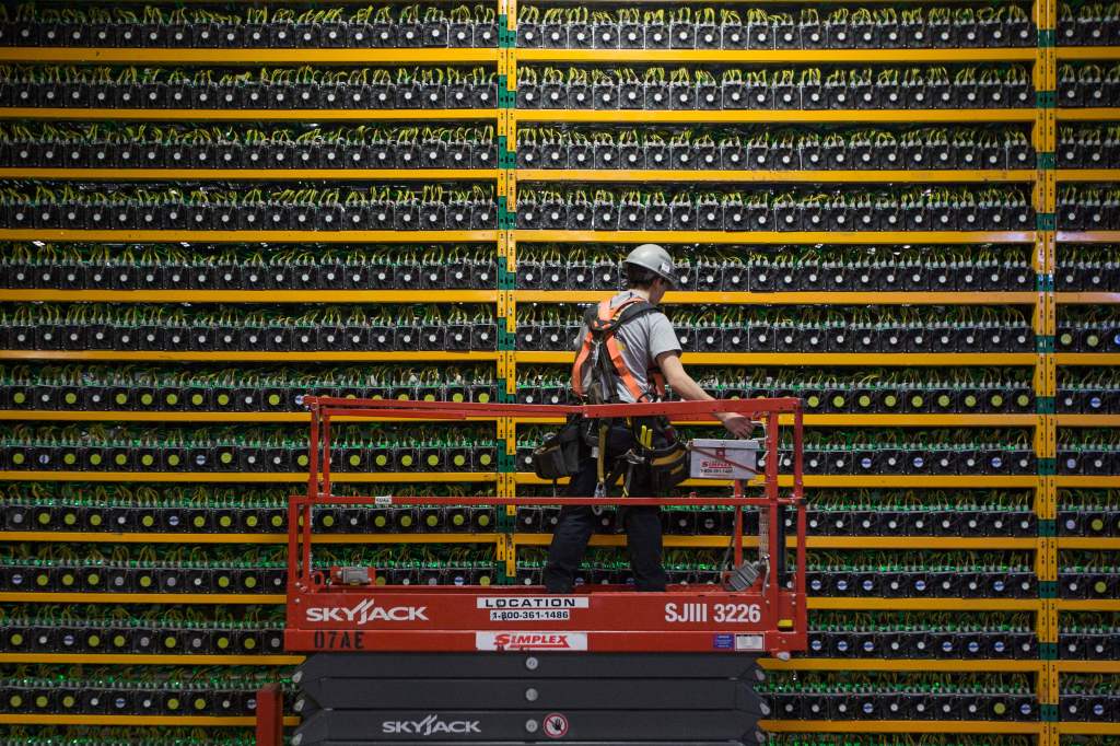 A technician inspects the backside of bitcoin mining at Bitfarms in Saint Hyacinthe, Quebec.