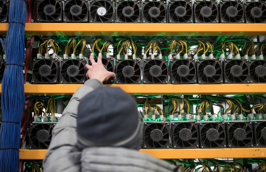 A worker checks the fan on a miner, at the cryptocurrency farming operation, Bitfarms, in Farnham, Quebec, Canada.